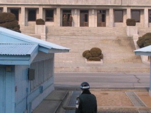 A South Korean soldier stares at his North Korean counterparts in a neutral portion of the DMZ separating the two countries.