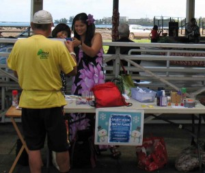 Eden Patino, right, of the Downtown Hilo Improvement Association assisted in the making of snow flakes. Photo by Dave Smith.