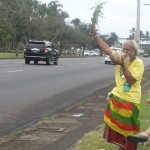 Sovereignty activist Abel Lui waving at passing motorists on Kamehameha Avenue this afternoon. Photo by Dave Smith.
