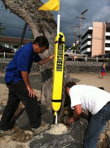 Kevin Sakai of the county Department of Parks and Recreation, left, and Mike Varney scout a location for a rescue tube at Magic Sands beach in Kona. Foundation photo.