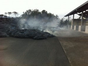 This photo, taken Nov. 13, shows the flow entering the Pahoa transfer station. There are no active toes of lava in the image, but the lava is still hot enough to burn the asphalt beneath, creating visible white smoke. HVO photo.