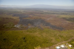 In this photo, taken on Feb. 19, another view of the leading portion of the June 27th flow, looking upslope. Pahoa Marketplace is in the lower right corner of the photograph. Mauna Loa can be seen near the top of the photograph. USGS HVO photo.