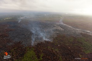 In this photo taken on Feb. 9, a breakout along the southern perimeter looks to have advanced within the flow's boundaries (lighter toned lava on the right), and now begins to enter the brush. Photo credit: Extreme Exposure Media/Paradise Helicopters. 