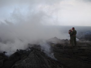 After establishing an appropriate location to resume VLF measurements over the June 27 lava tube to estimate the cross-sectional area of lava within the tube, HVO geologists on March 17 make the measurements, sometimes requiring walking through volcanic gases. USGS HVO photo.