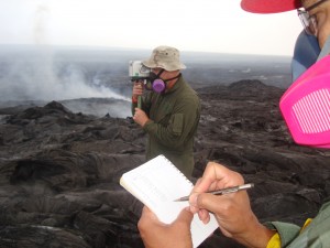The VLF radio wave, transmitted from the Lualualei Naval Base on Oʻahu, is received by the handheld device. The numbers are read and recorded. These data will allow the estimation of the cross-sectional area of lava within the tube. This photo, taken March 17, shows scientists going through the process. USGS HVO photo.