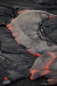 April 16, 2015. The cooled surface of a pahoehoe flow breaks loose, releasing molten lava in the middle of the flow field. Photo credit: Extreme Exposure Media/Paradise Helicopters.