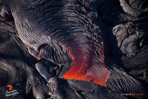 July 16:  The cooling surface of a finger of pahoehoe cools rapidly, forming a wrinkly, textured skin.  Photo: Extreme Exposure Media/Paradise Helicopters.