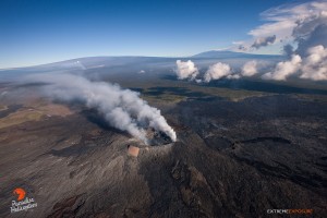 July 16: Beautiful view above Pu‘u ‘O‘o crater, with Mauna Loa and Mauna Kea in the background. A plume from Halema‘uma‘u can be seen in front of Mauna Loa in the upper left of the frame.  Photo: Extreme Exposure Media/Paradise Helicopters.