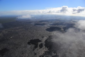  Lava flows are scattered across a broad area extending from about 3 to 8 km (2–5 mi) northeast of Puʻu ʻŌʻō. The active flows start just above the horizontal mid-line of the photo, but cannot be picked out easily within the broader inactive flow field due to their distance away in this photo. USGS/HVO photo.