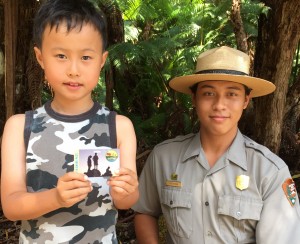 Young park visitor Ethan displays the new Every Kid in a Park free pass for 4th graders and enjoys the Exploring the Summit hike with Ranger Alakea Bidal in Hawai‘i Volcanoes National Park. National Park Service photo.