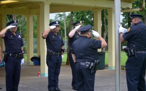 Officer salute as the United States and Hawai'i flags are raised at Lincoln Park in Hilo. HPD photo.