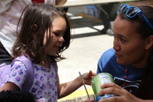 Malia Kealoha of Maui, a camper at last summer's Science Camp, shares a chemistry experiment with a young attendee at the Volcano Village 4th of July Festival. Courtesy photo.
