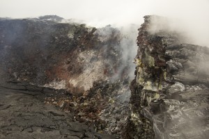 The altered and fractured rim of Puʻu ʻŌʻō Crater is prone to small collapses. Portions of the eastern crater rim, shown here, have collapsed onto the crater floor, covering the recent lava flows with rubble.USGS/HVO photo.