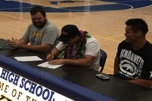 Seth Fukushima (center) signed his Letter of Intent on Monday to play football at Whitworth College, flanked by assistant coaches Chris Todd (left) and Jordan Loeffler (right). Photo by Josh Pacheco.