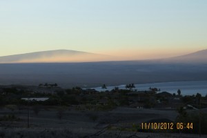 The summit of Mauna Loa (left) rises above the vog layer on the leeward side of the Island of Hawai‘i in November 2012. The flank of Hualālai is visible at right. USGS photo. 