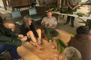 Ranger Dean shows visitors how to make tī leaf lei at Kīlauea Visitor Center. NPS Photo/David Boyle 
