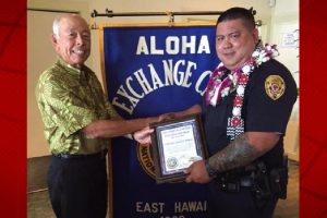 Aloha Exchange Club member Joey Estrella presents an 'Officer of the Month' award to Officer Jared Cabatu. HPD photo.