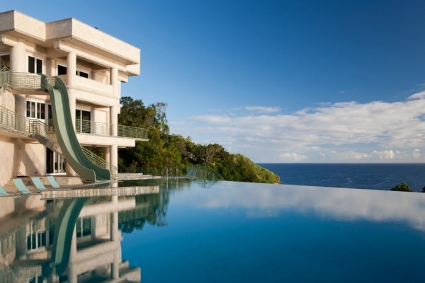 An olympic infinity pool dominates the front of the mansion.