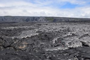 As Kīlauea Volcano’s active pāhoehoe flow spreads across the coastal plain on July 6, the new lava appeared more shiny or silvery compared with the older lava beneath it. Molten “toes” of lava breaking out from the leading edges of the flow can be seen in the lower right quadrant of the photo. USGS photo.