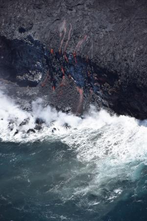A close-up view of the ocean entry with multiple small fingers of lava spilling over the cliff. USGS photo.