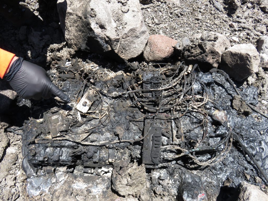 Volcano monitoring equipment installed on the rim of Halemaʻumaʻu Crater was a casualty of Saturday night's explosive event. This pile of charred wires and metal components, surrounded by melted plastic, is all that remains of the power supply for one of HVO's gravity instruments located about 80 feet from the crater rim. USGS/HVO photo.