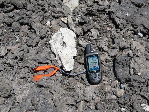 Tephra blasted from the summit vent on Saturday night included lithic (solid rock) fragments from the vent wall as well as spatter (molten lava fragments) ejected from the lava lake. The light-colored lithic in the center of this photo is about 8 inches long—the GPS unit is shown for scale. Tephra, the general term for volcanic rock fragments exploded or carried into the air during an eruption, can range from dust-size particles to fragments more than 3.2 feet in diameter.