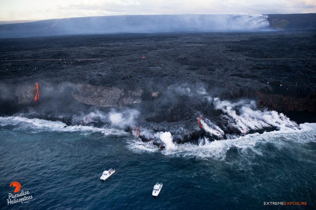 Kalapana fly-over, Thursday, Aug. 4, 6 a.m. A view looking west at the 61G’s ocean entry. Rising gases demark the path of the lava from Pu‘u ‘O‘o (the little bump on the horizon), and down Pulama Pali, while the delta of new land continues to increase in size, and now extending approximately 40-50 yards from the base of the sea cliff.