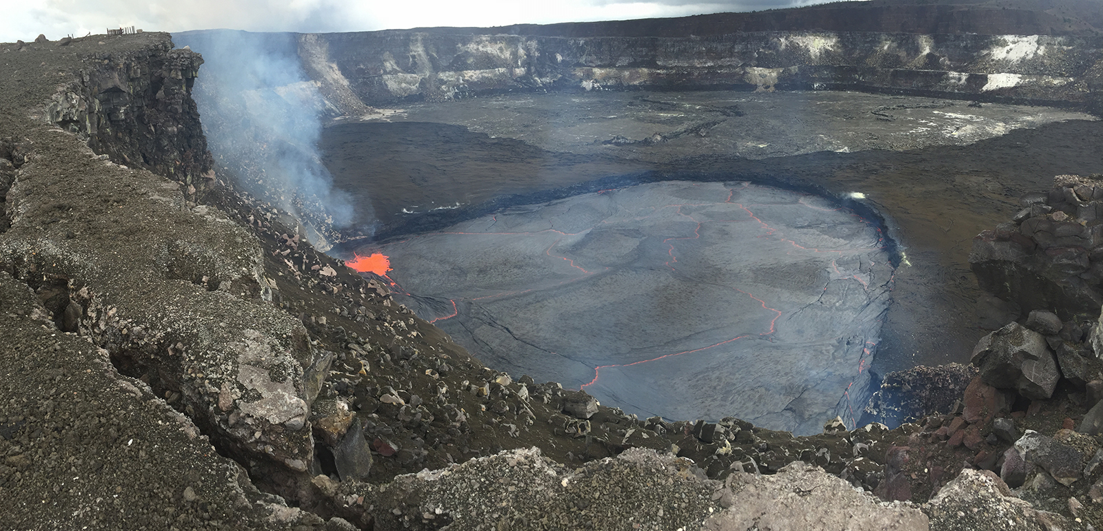 On Sept. 10, 2016, Kīlauea Volcano’s summit lava lake rose to within 16 feet of the vent rim. This is the highest level the lake has reached since it overflowed the vent in April-May 2015, when lava flowed onto the floor of Halemaʻumaʻu Crater, forming the dark-colored rock visible on either side of the vent. Charred and broken fencing (upper left) is all that remains of a former visitor overlook, closed to the public since 2008 due to explosions, volcanic gas emissions, and other hazards associated with the lava lake. USGS photo.