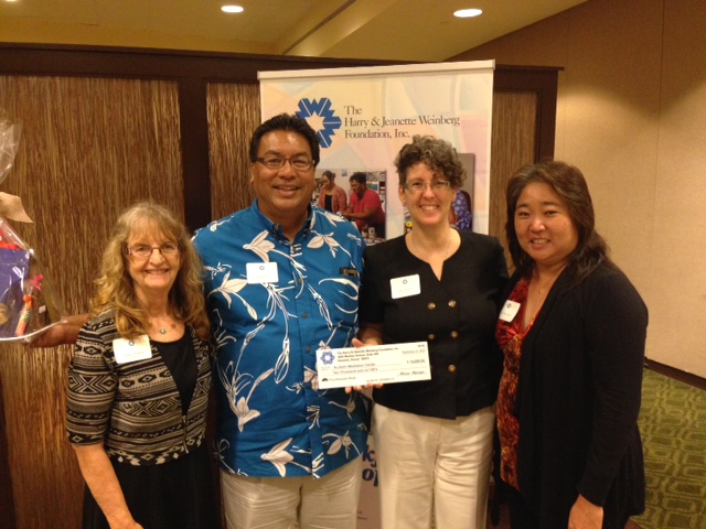 On behalf of Kuʻikahi Mediation Center, Executive Director Julie Mitchell (center) received $10,000 from Kathie Yamashiro (right) representing The Harry & Jeanette Weinberg Foundation, Inc. Courtesy photo.