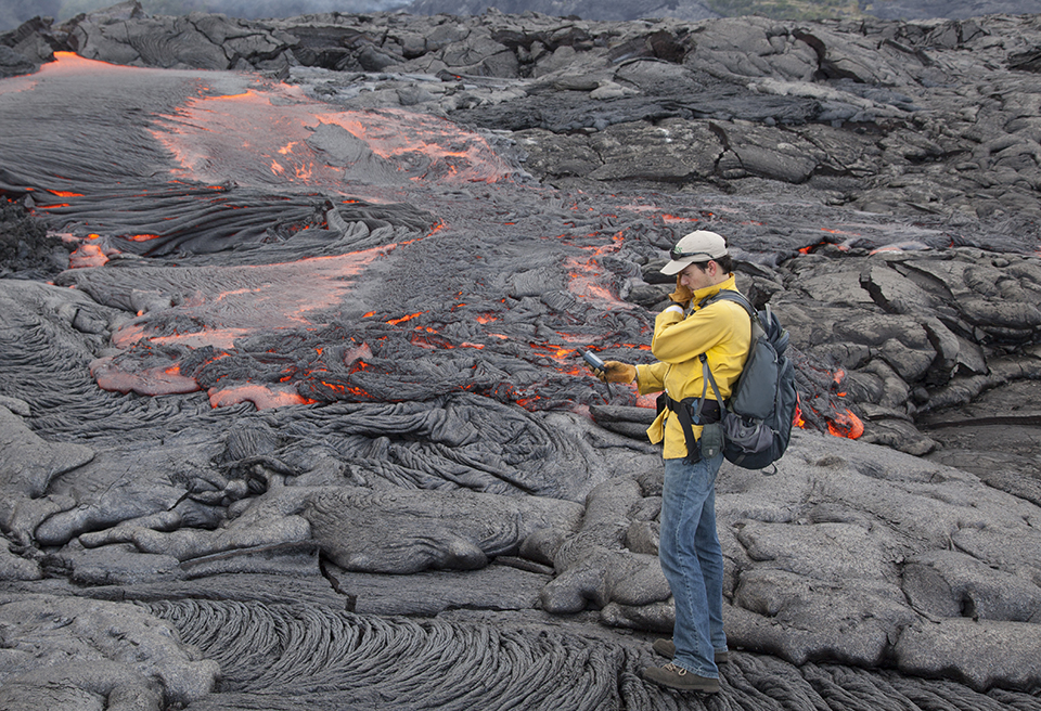 Hawaiian Volcano Observatory geologist mapping a lava flow in 2012. USGS photo.
